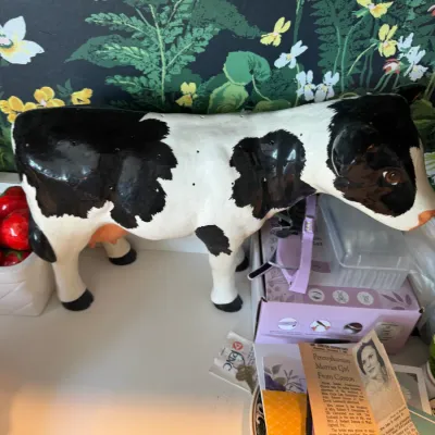 Sale Photo Thumbnail #29: Vintage painted ceramic Holstein cow figurine standing on a counter.
