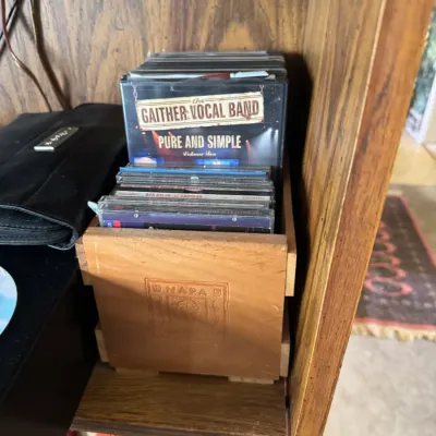 Sale Photo Thumbnail #304: Collection of CDs stored in a wooden Napa Valley crate, featuring titles such as Gaither Vocal Band's 'Pure and Simple'.