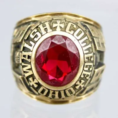 Sale Photo Thumbnail #21: Walsh College Ohio class ring featuring a central faceted red stone set in yellow gold tones.