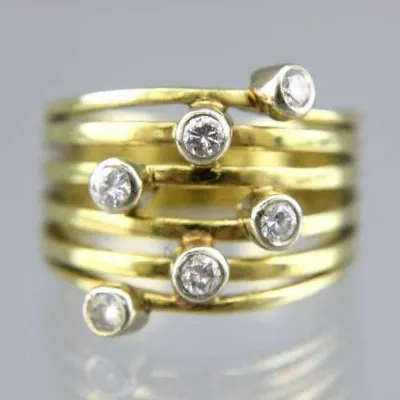 Sale Photo Thumbnail #23: Modernist multi-band gold statement ring featuring scattered bezel-set clear gemstones.