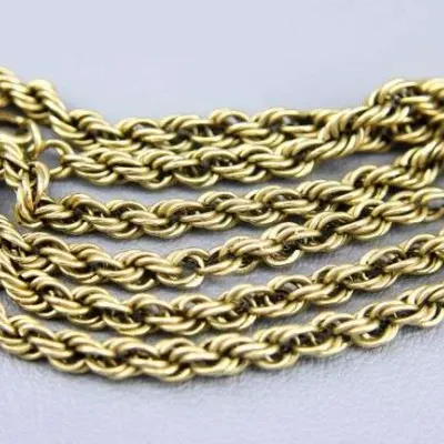 Sale Photo Thumbnail #13: Gold-tone rope chain necklace, coiled and resting on a neutral gray background.