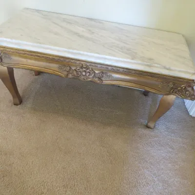 Sale Photo Thumbnail #69: French Provincial style coffee table featuring a rectangular white marble top and an ornate gilded frame with carved floral details and cabriole legs.