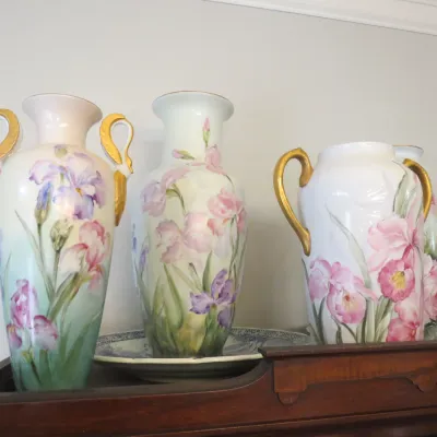Sale Photo Thumbnail #24: Collection of hand-painted porcelain floral vases with gilt handles, featuring delicate iris motifs in an antique Art Nouveau style.