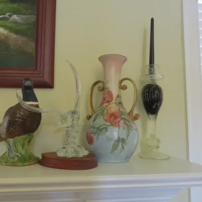 Sale Photo Thumbnail #35: Collection of decorative items including a ceramic pheasant figurine, a clear glass sculpture, a hand-painted floral porcelain vase, and a glass candlestick holder.