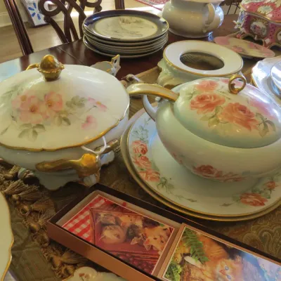 Sale Photo Thumbnail #27: Collection of antique hand-painted porcelain tureens and serving plates with floral motifs and gilded accents.