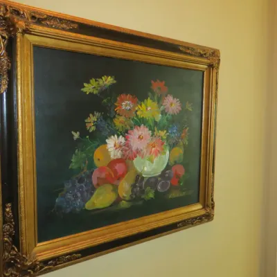 Sale Photo Thumbnail #46: Framed floral and fruit still life oil painting on canvas, housed in an ornate gilt and black wooden frame.