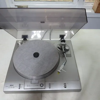Sale Photo Thumbnail #134: Vintage Akai AP-D30 direct drive auto-return turntable with a clear dust cover, grey slipmat, and silver chassis, circa 1980s.