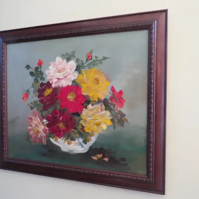 Sale Photo Thumbnail #21: Framed floral still life oil painting depicting a vase of colorful roses, set in a dark wood frame with molded detail.