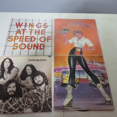 Sale Photo Thumbnail #93: Lot of three vintage vinyl LP records from the 1970s, including Paul McCartney and Wings' "Wings at the Speed of Sound", the self-titled "Looking Glass" album, and the gatefold soundtrack for "American Graffiti".