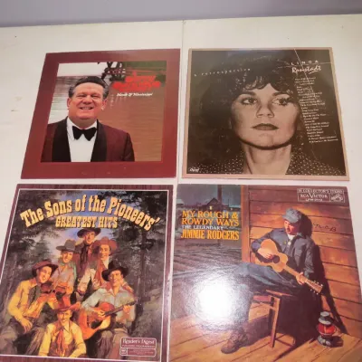Sale Photo Thumbnail #96: Collection of four vintage country and pop vinyl albums, featuring artists like Linda Ronstadt, Jerry Clower, The Sons of the Pioneers, and Jimmie Rodgers.