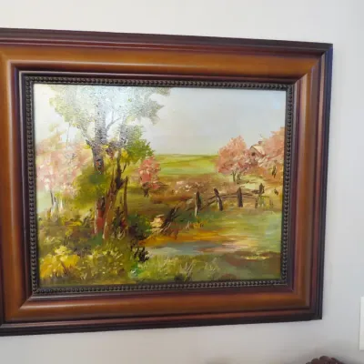 Sale Photo Thumbnail #28: Framed impressionistic landscape oil painting depicting a rural field with trees and a stream, housed in a heavy wooden frame with beaded trim.