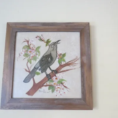 Sale Photo Thumbnail #40: Framed original painting depicting a grey bird perched on a flowering branch, signed by artist Helen Pastine.