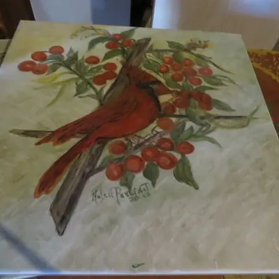 Sale Photo Thumbnail #68: Hand-painted square ceramic tile or canvas depicting a male cardinal perched on a berry branch, signed Helen Pavlides and dated 2004.