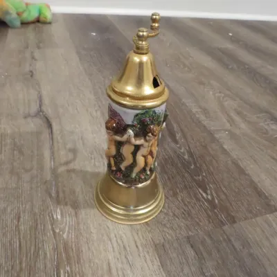 Sale Photo Thumbnail #57: Vintage ceramic and brass pepper mill or spice grinder featuring a relief design of cherubs and garden motifs.