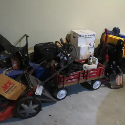 Sale Photo Thumbnail #45: Assorted household and yard items, including a walk-behind lawn mower, a vintage red Radio Flyer wooden wagon, storage boxes, luggage, and a folding walker.