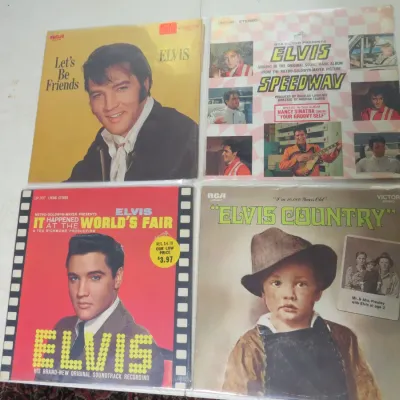 Sale Photo Thumbnail #140: Collection of four vintage Elvis Presley vinyl LP records, including Let's Be Friends, Speedway, It Happened at the World's Fair, and Elvis Country, in protective plastic sleeves.