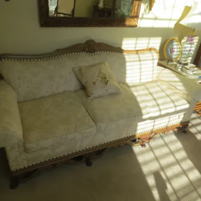 Sale Photo Thumbnail #7: French Provincial style sofa with carved wooden trim, shell crest motif, and cream damask upholstery.