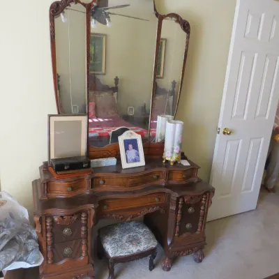 Sale Photo Thumbnail #75: Antique carved wood vanity with a tri-fold mirror, claw-and-ball feet, and a matching upholstered stool.
