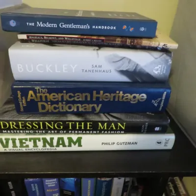 Sale Photo Thumbnail #84: Stack of hardcover and paperback books, including reference, history, biography, and men's fashion titles.