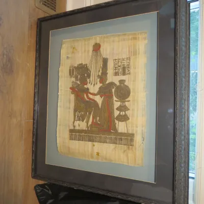 Sale Photo Thumbnail #43: Framed Egyptian papyrus art depicting royal figures under the sun disc Aten, presented in a dark wooden frame with double matting.