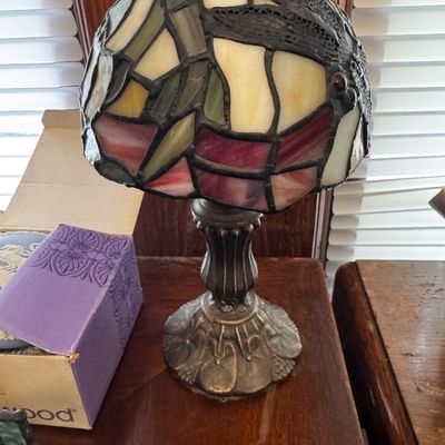 Sale Photo Thumbnail #3: Small Tiffany-style stained glass accent lamp featuring a dragonfly pattern shade over a cast metal base.