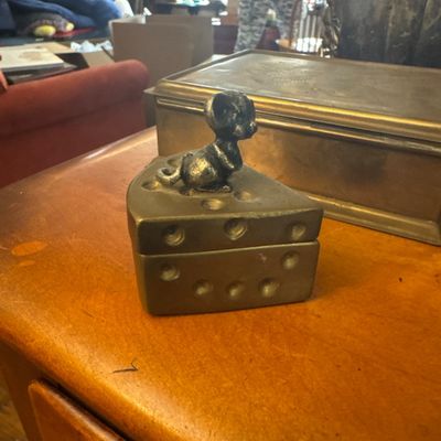 Sale Photo Thumbnail #26: Vintage metal mouse and cheese wedge trinket box featuring a dark metal mouse finial on a cheese slice-shaped container.