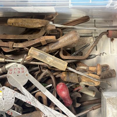 Sale Photo Thumbnail #81: Clear plastic storage tote filled with vintage hand tools, including rasps, pliers, wood-handled screwdrivers, and calipers.