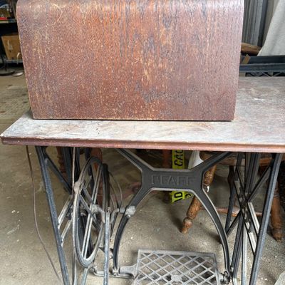 Sale Photo Thumbnail #55: Vintage Pfaff treadle sewing machine featuring a cast iron base, wooden tabletop, and a domed bentwood protective cover with a metal handle.