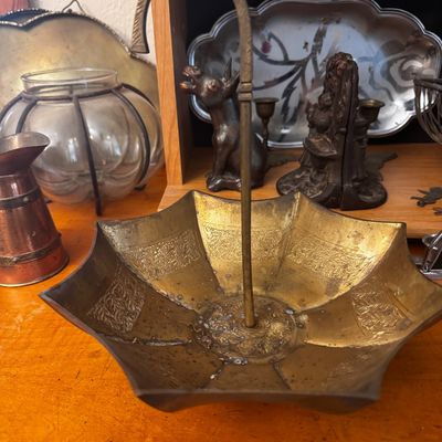 Sale Photo Thumbnail #49: Vintage brass upside-down umbrella catchall tray with etched leaf patterns and a hook handle. Shows light patina and wear consistent with age.