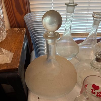 Sale Photo Thumbnail #7: Collection of vintage glass decanters and glassware, including a large frosted globe-stopper decanter and a blue ribbed vase.