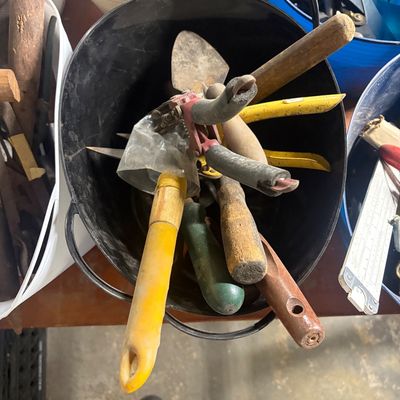 Sale Photo Thumbnail #65: Black metal tub filled with vintage hand tools, garden trowels, and wire cutters showing signs of heavy use.