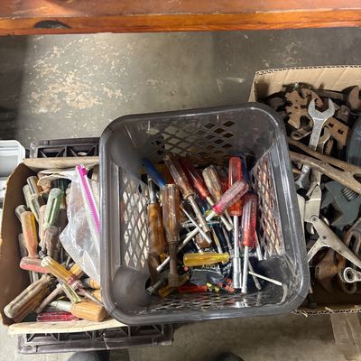 Sale Photo Thumbnail #76: Assorted vintage hand tools including screwdrivers and wrenches organized in plastic bins and cardboard boxes.