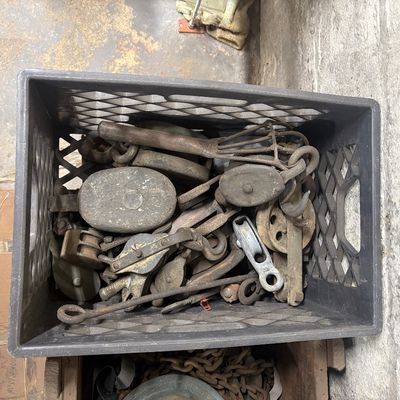 Sale Photo Thumbnail #62: Black plastic crate filled with assorted vintage metal and wood pulleys, hooks, and hardware.