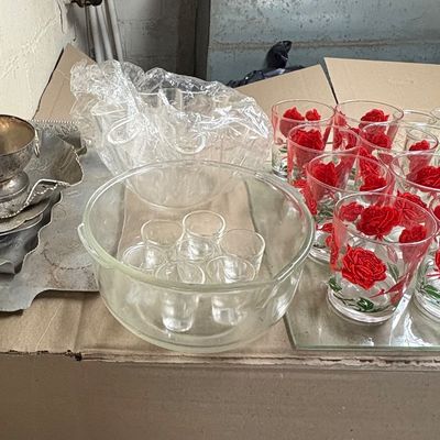 Sale Photo Thumbnail #96: Collection of vintage glassware and silverplate serving pieces, including drinking glasses with red rose motifs and small clear punch cups inside a large bowl.