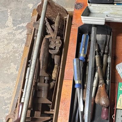 Sale Photo Thumbnail #70: Collection of vintage hand tools including wooden tool caddies, metal tool tray, screwdrivers, pipe wrenches, and soldering gun.