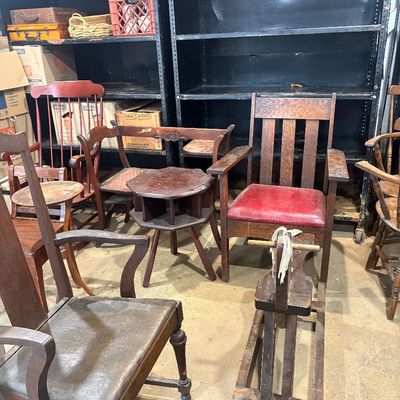 Sale Photo Thumbnail #58: Collection of vintage wooden seating and accent furniture, including an Arts and Crafts style armchair with red leatherette upholstery, a child's wooden rocking horse, and various wooden chairs and side tables.