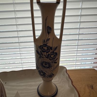 Sale Photo Thumbnail #20: Hand-painted ceramic urn vase featuring high angular side handles and a blue floral motif over a beige background.