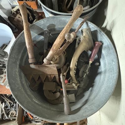 Sale Photo Thumbnail #74: Galvanized metal tub filled with an assortment of vintage hand tools, including hand drills and wooden-handled utensils.