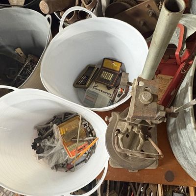 Sale Photo Thumbnail #73: Collection of workshop tools and hardware stored in white plastic flex tubs, alongside a vintage manual drill press stand.