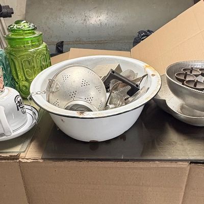 Sale Photo Thumbnail #94: Assorted vintage kitchenware including green and blue glass canisters, an enameled basin with aluminum utensils, novel teacups, and aluminum serving bowls.