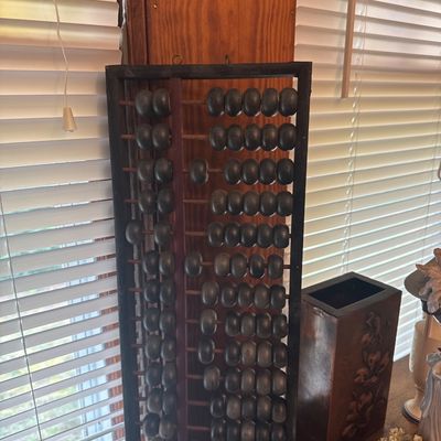 Sale Photo Thumbnail #28: Vintage Asian wooden abacus counting tool with dark finish and metal hanging loops, displayed next to a carved wooden box.