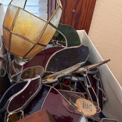 Sale Photo Thumbnail #17: Box filled with vintage leaded stained glass suncatchers and small decorative items, including a capiz shell basket ornament.