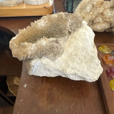 Sale Photo Thumbnail #19: Large quartz geode mineral specimen displayed on a wooden surface.