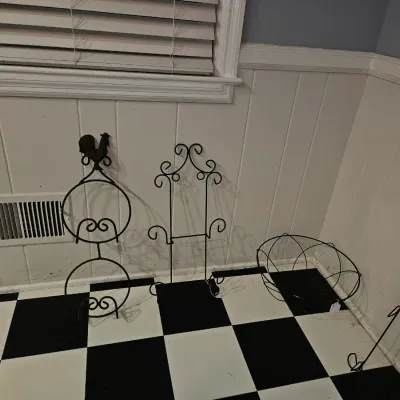 Sale Photo Thumbnail #40: Collection of black wrought iron decor, including display stands, a rooster-topped holder, and a wire basket.