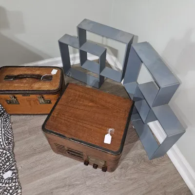 Sale Photo Thumbnail #68: Vintage tabletop radio cabinet paired with a brown train case train luggage and two grey geometric wall shelf units.