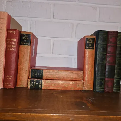 Sale Photo Thumbnail #5: Collection of vintage hardbound books, including works by Kipling, Shakespeare, and Hawthorne, displayed on a wooden shelf.
