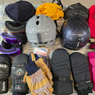 Sale Photo Thumbnail #139: Collection of winter sports gear, featuring ski helmets from Giro and Leedom, goggles, and various insulated gloves and mittens from brands like Reusch and Hotfingers.