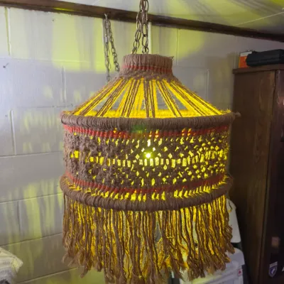 Sale Photo Thumbnail #191: Vintage 1970s macramé swag lamp with brown jute, red accent stitching, and hanging fringe.