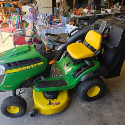 Sale Photo Thumbnail #4: John Deere S240 riding lawn tractor equipped with a yellow seat and a rear bagger attachment.