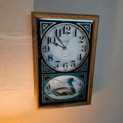 Sale Photo Thumbnail #165: Vintage Verichron quartz wall clock featuring an oak frame and a lower glass panel depicting a mallard duck in a marsh.